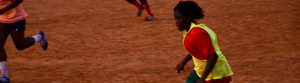 Young woman playing football in Camroon