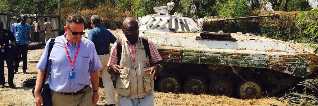 Professor Clapham walks in South Sudan, UN tanks in the background