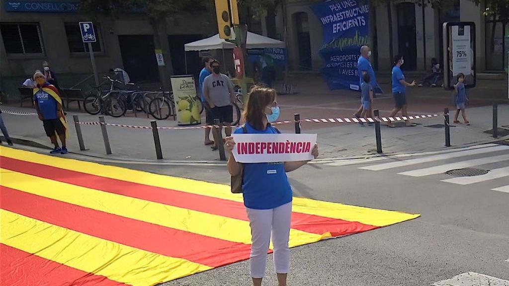 Photo of a woman holding a sign. Credits to Joan Brucet