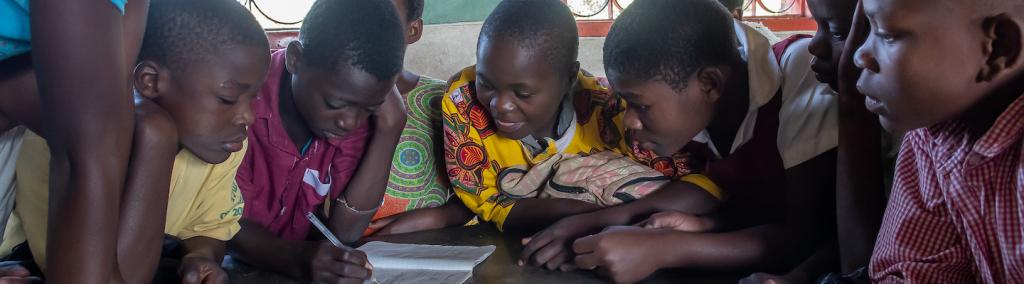 Children in their school classroom working on an essay, Mzuzu, Malawi.