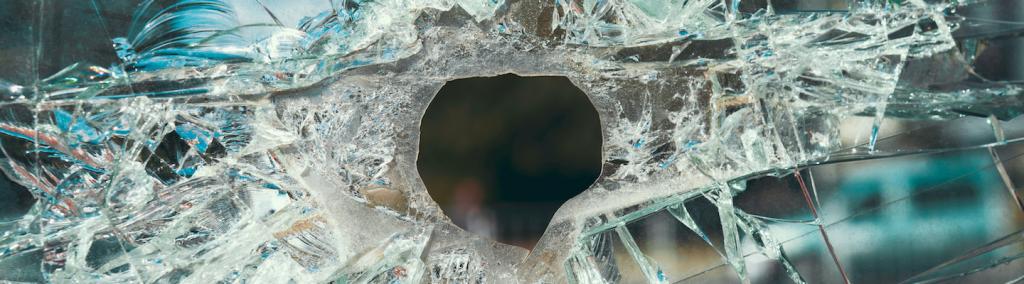 Cracked glass with a hole from a bullet.