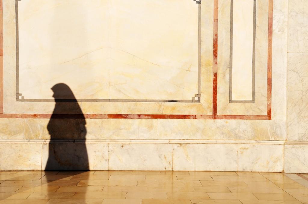 A woman's shadow at the Umayyad Mosque in Damascus, Syria. She is wearing a chador.