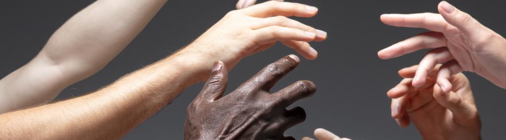 Hands of different people in touch isolated on grey background