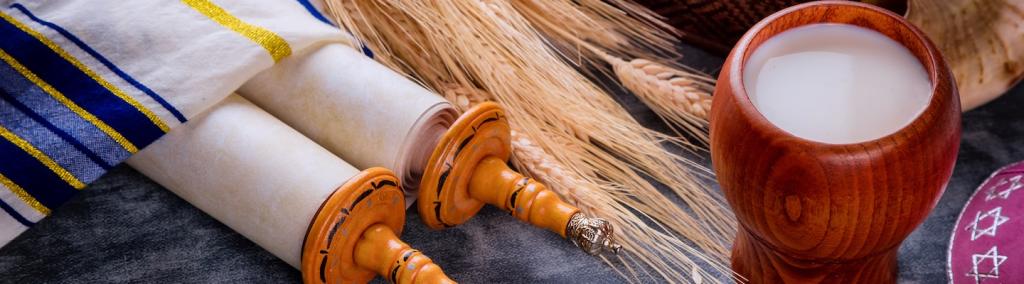 Jewish holiday Shavuot for kosher set dairy food on torah scroll and tallis.