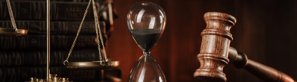 Photo showing judge gavel, scales and hourglass