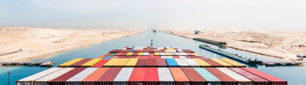 Vue sur des conteneurs chargés sur le pont d’un cargo transitant par le canal de Suez sur sa route commerciale internationale.