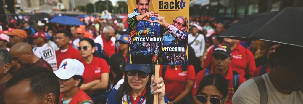 VENEZUELA, Caracas. A demon- strator holds a banner during a march in Caracas to demand the release of deposed Venezuelan President Nicolas Maduro and his wife Cilia Flores. 13 January 2026. Juan BARRETO/ AFP