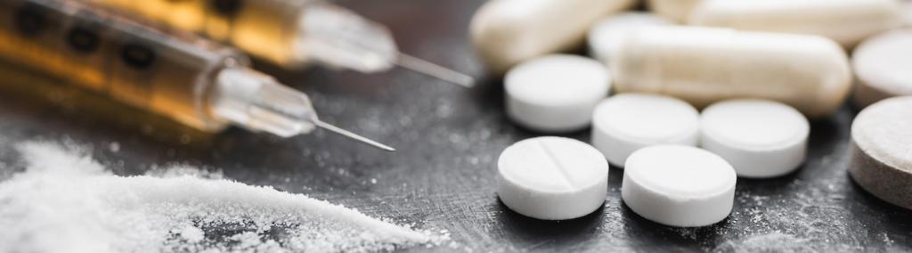 Stupéfiants, drogue en poudre, seringues et pilules blanches
