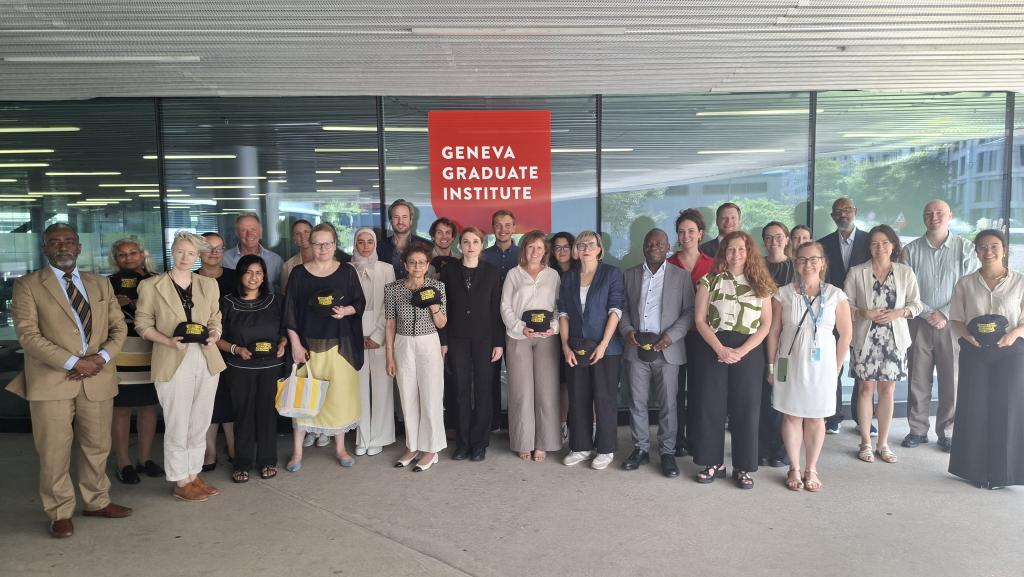 Group photo of people standing in front of the Geneva Graduate Institute entrance sign