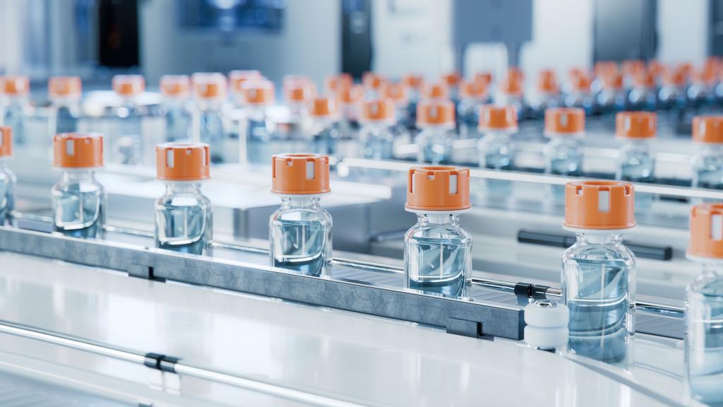 The image shows a vaccine vial production line.