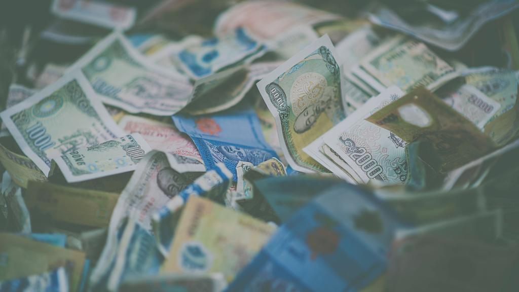 A close-up view of diverse international currency banknotes in soft focus, conveying wealth and finance themes.