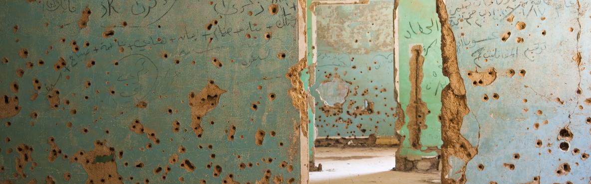 A wall riddled with bullet holes