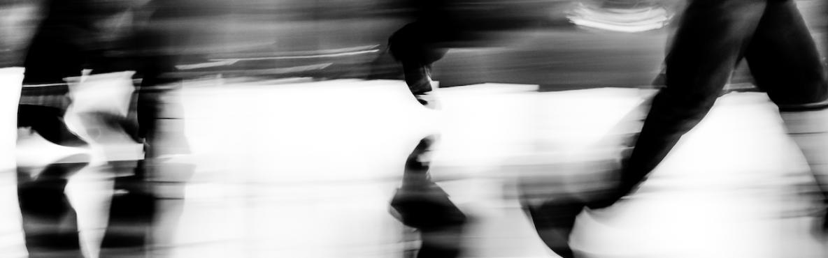 Black and white, blurry legs of people walking