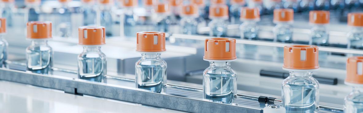 The image shows a vaccine vial production line.