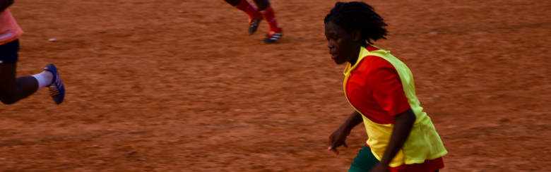 Young woman playing football in Camroon