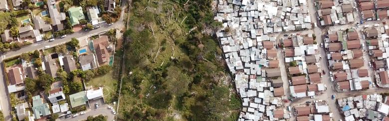 Rich houses and poor houses divided by a fence