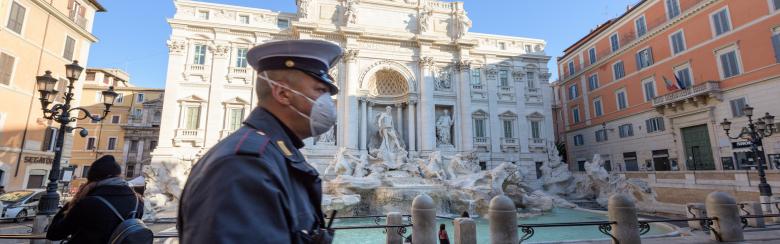 Italian carabineri walks in front of trevi fountain in Rome