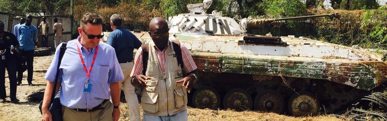 Professor Clapham walks in South Sudan, UN tanks in the background