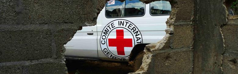 A hole in a wall showing an ICRC truck