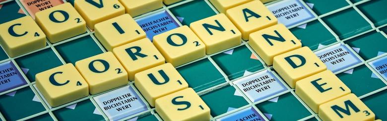 Scrabble game showing the words covid, virus, corona and pademic