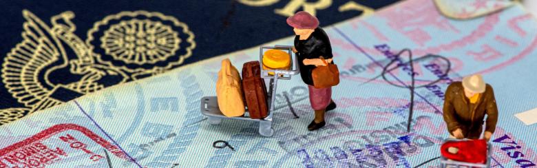 photo of a passport with tiny action figures of people travelling