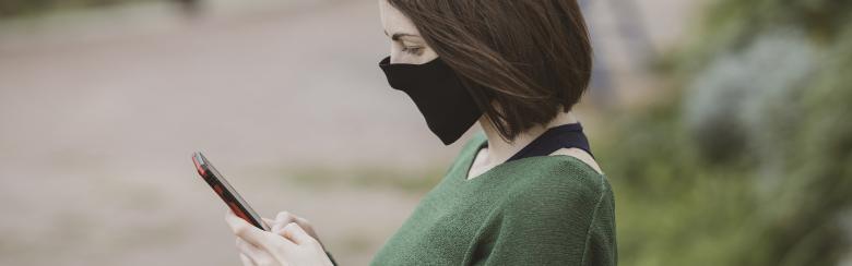 Person with face mask holding a phone