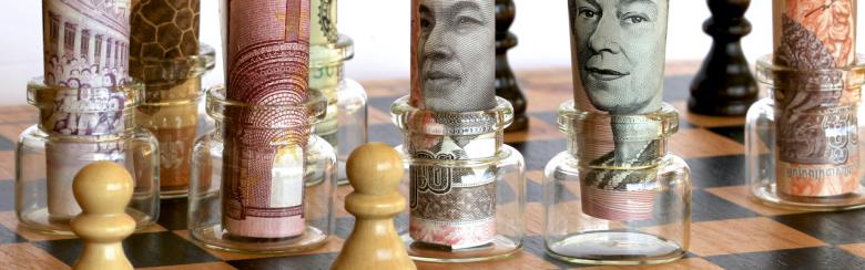 King and Queen and mixed currency notes on a chess board.
