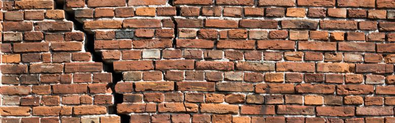 Old, cracked red-brick wall.