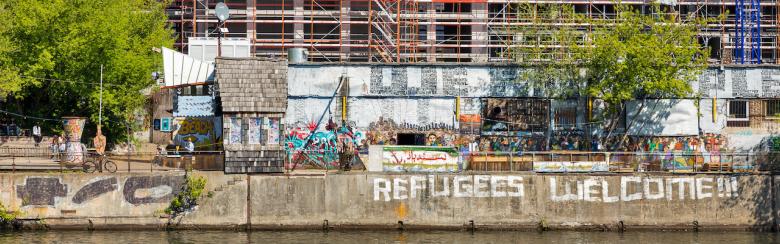 YAAM night club with sign “Refugees Welcome!” along the Spree riverbank in Berlin.