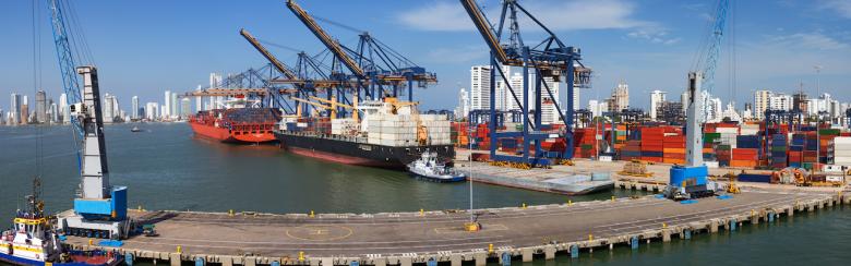 Panoramic view of a port activity with cargo ships, cranes and containers at the pier of the port of Cartagena, Colombia.