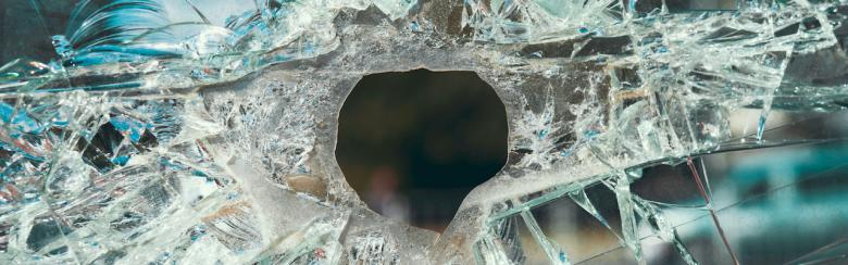 Cracked glass with a hole from a bullet.