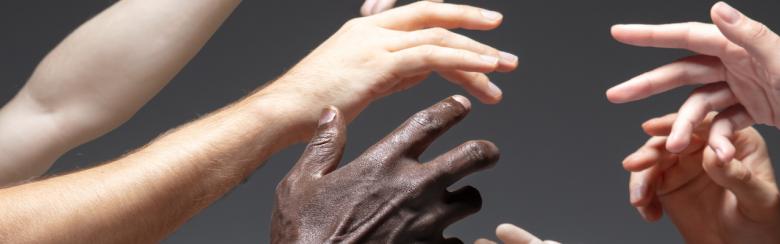 Hands of different people in touch isolated on grey background