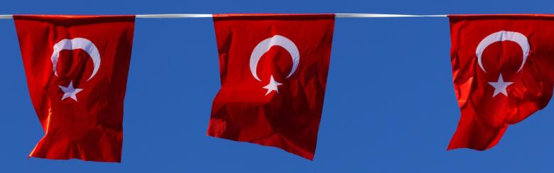 Three red Turkish flags with sunny blue-sky background