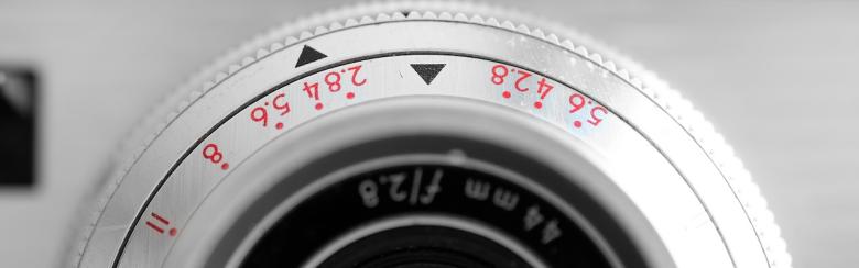 Black-and-white photo of an old camera with a manual lens 
