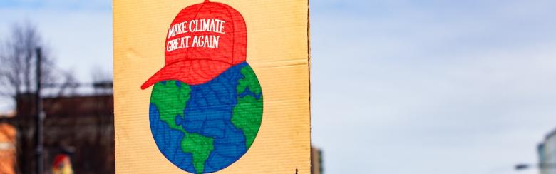 Pancarte en carton avec une image de la Terre coiffée de la casquette de Trump sur laquelle est inscrit « Make climate great again », lors d’une manifestation pour l’environnement. 