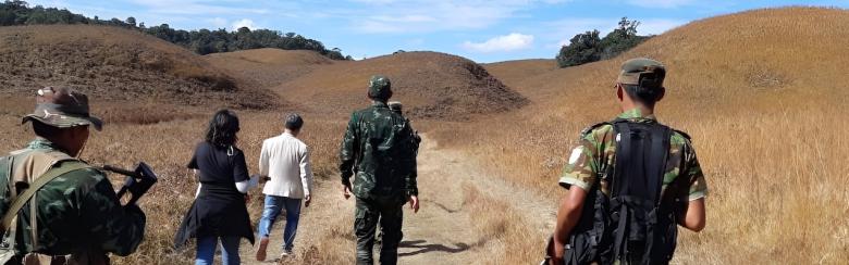 Image taken from the author's fieldwork, showing  from behind the author and a rebel group walking along a path. 