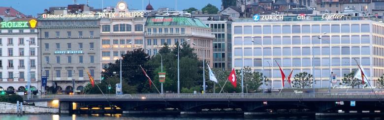 Old town cathedral and waterfront luxury brand offices in Geneva, Switzerland. 