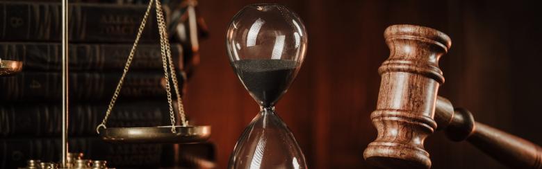 Photo showing judge gavel, scales and hourglass