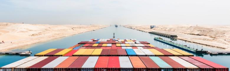 Vue sur des conteneurs chargés sur le pont d’un cargo transitant par le canal de Suez sur sa route commerciale internationale.