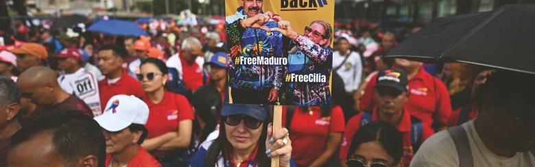 VENEZUELA, Caracas. A demon- strator holds a banner during a march in Caracas to demand the release of deposed Venezuelan President Nicolas Maduro and his wife Cilia Flores. 13 January 2026. Juan BARRETO/ AFP