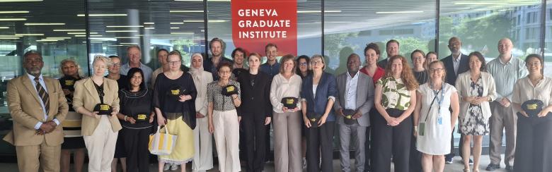Group photo of people standing in front of the Geneva Graduate Institute entrance sign