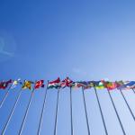 A set of world flags against a blue sky