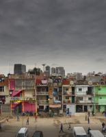 Picture of slums with dark clouds above.